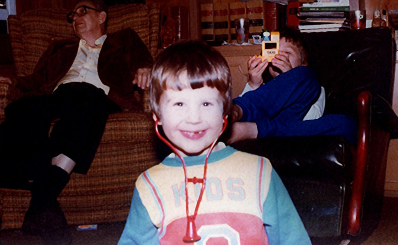 Greg Friberg as a young child playing with a stethoscope.