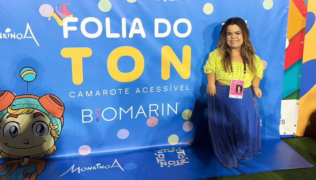 Rebeca Costa standing in front of a banner at Carnival