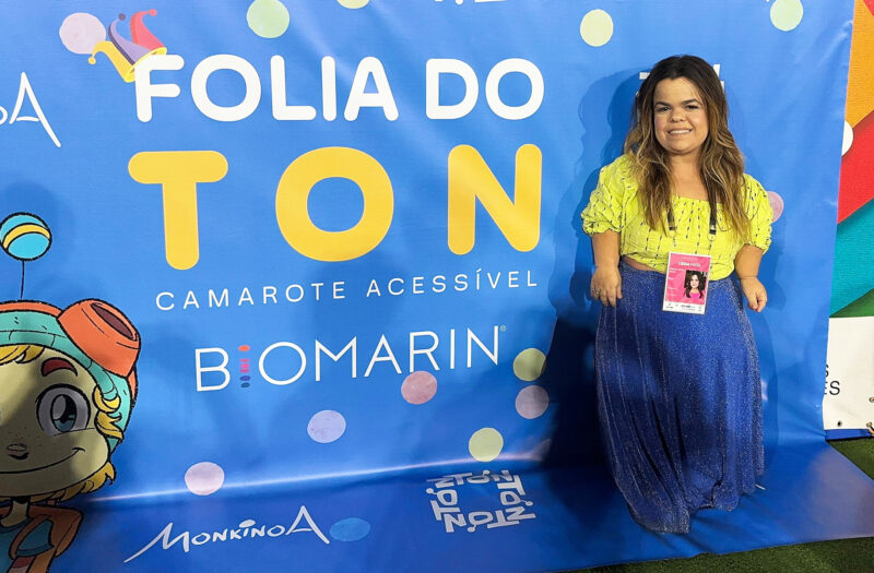 Rebeca Costa standing in front of a banner at Carnival