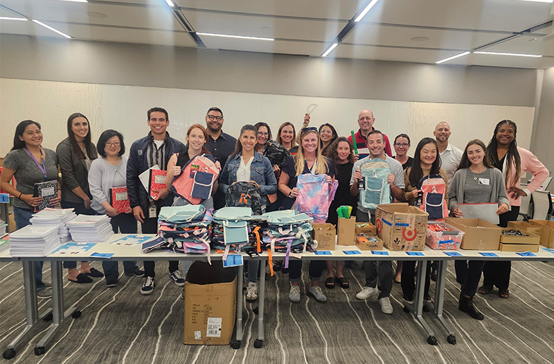 Employees putting together back-to-school backpacks for students.